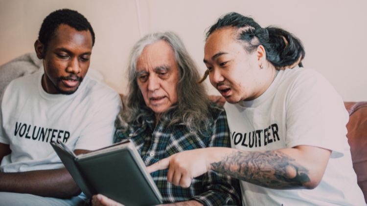 Two young men helping an older person on a volunteer travel trip