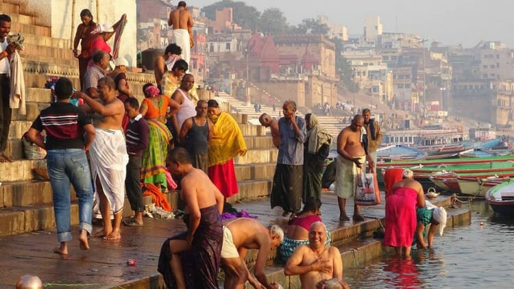 people bathing in the ganges river in  varanasi, india